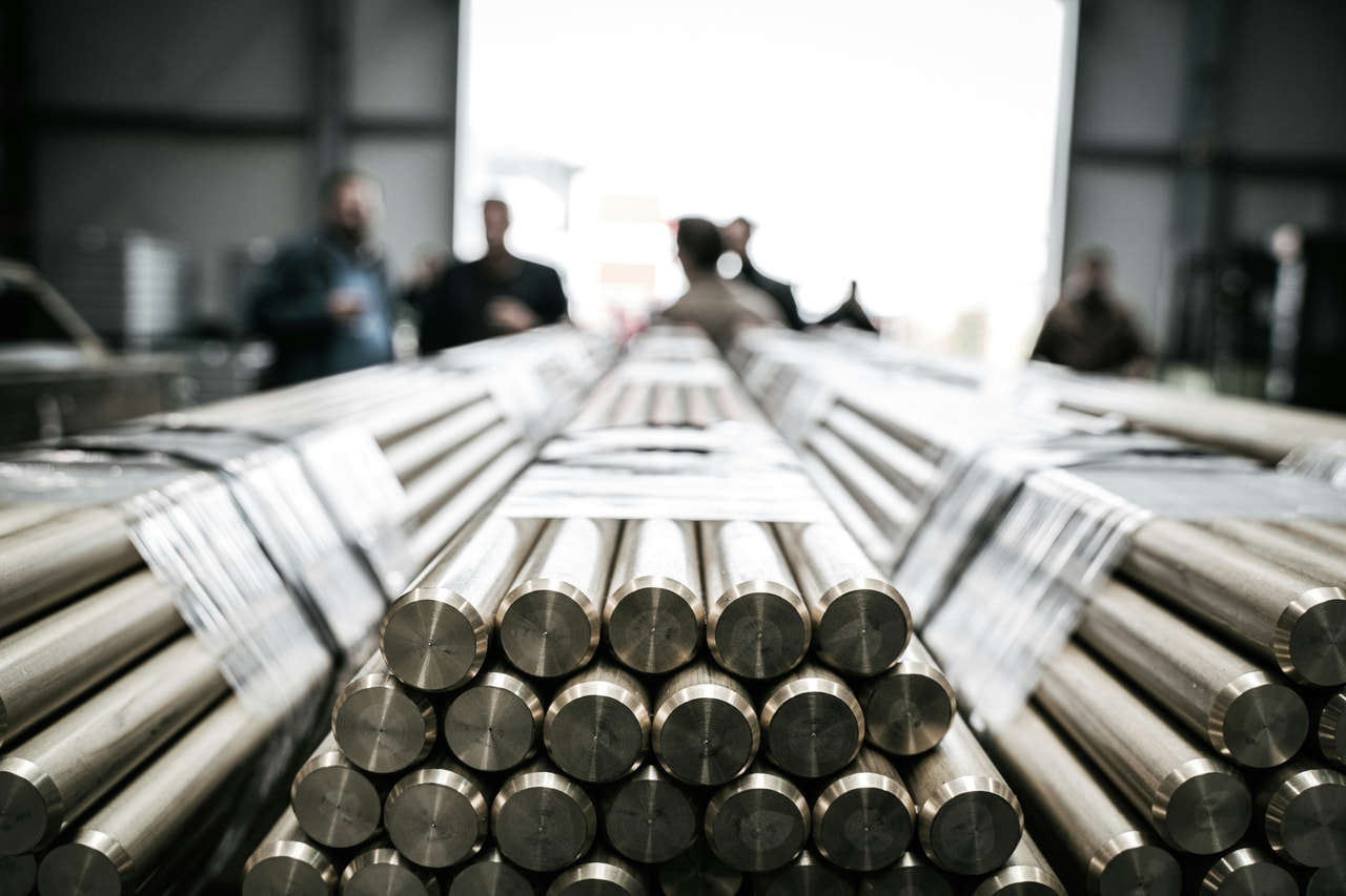 Bundles of bright steel round bar stacked in a warehouse